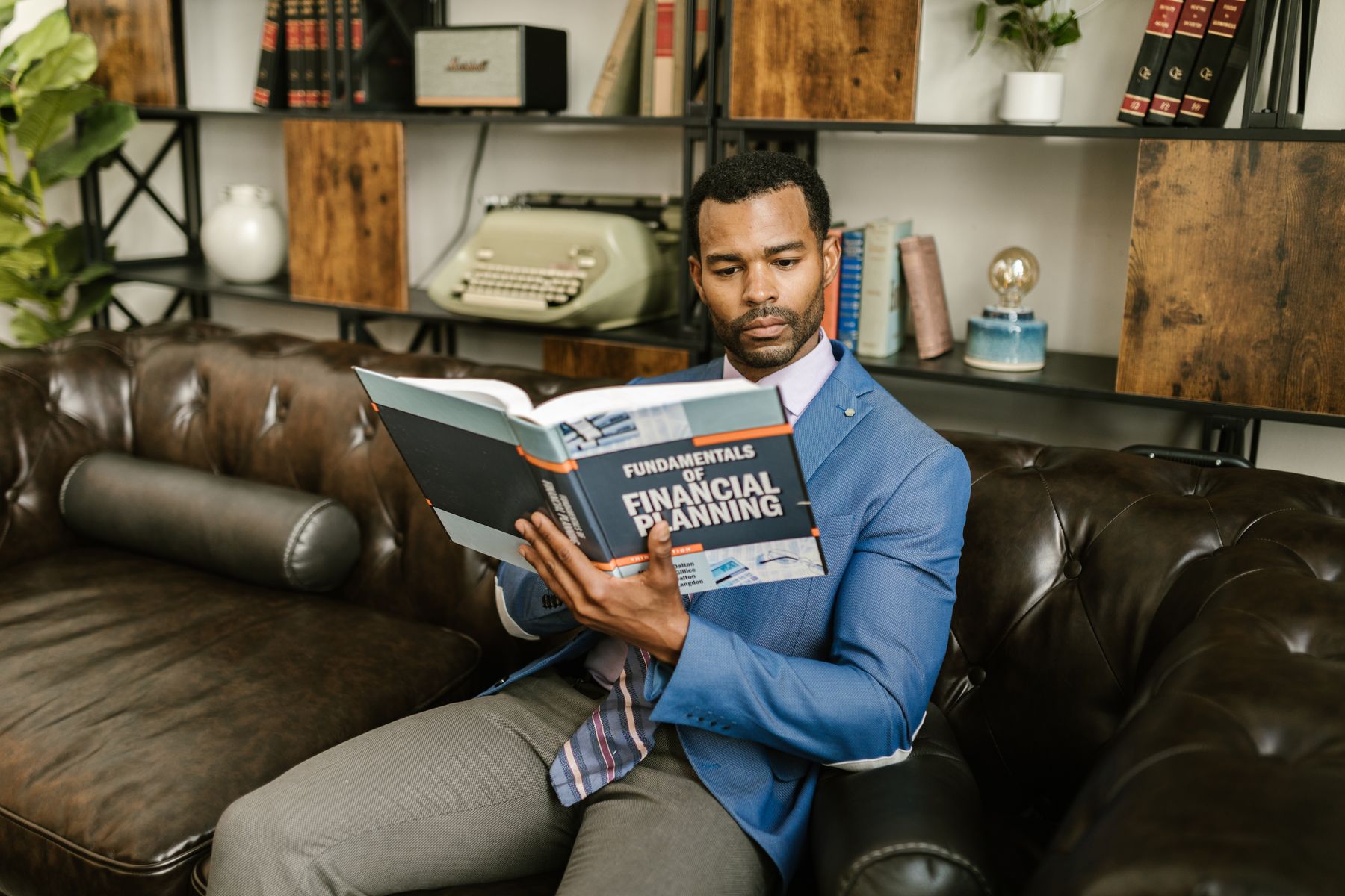 A person seated and reading printed financial planning material